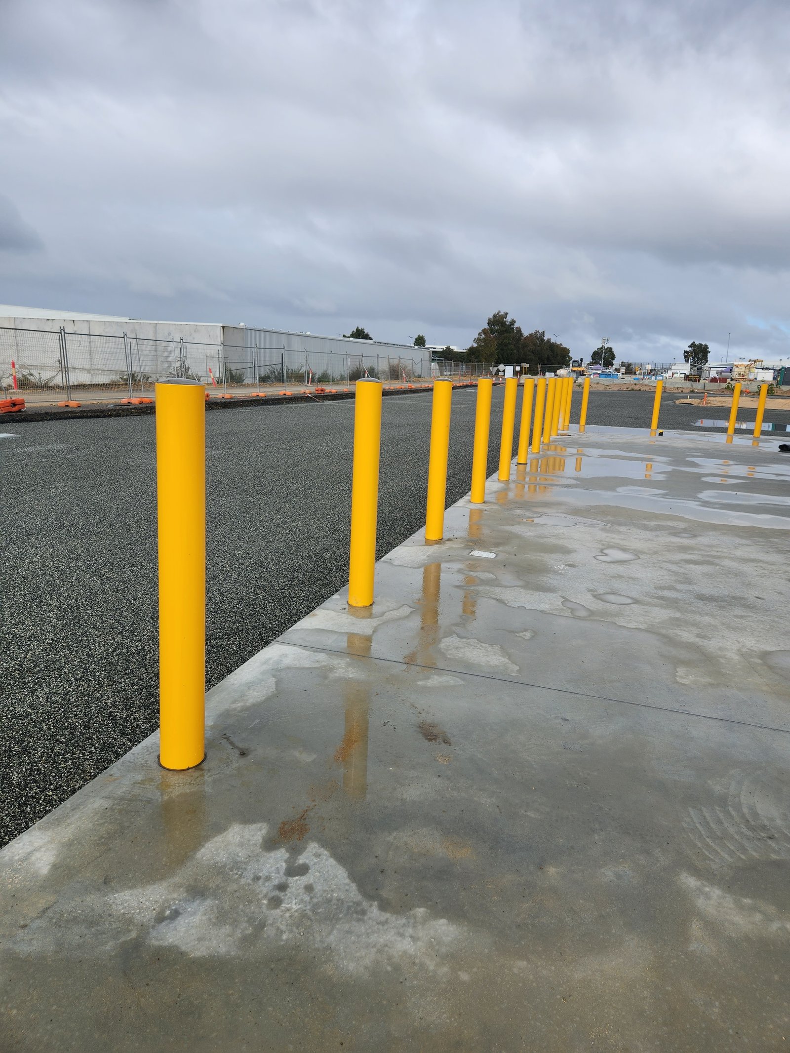 Yellow safety bollards installed at an industrial site